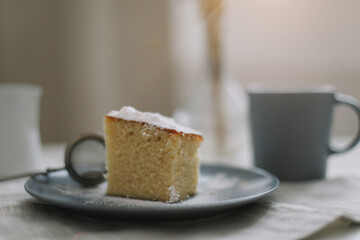 Piece of homemade cake with a cup of cappuccino on table with linen tablecloth. Morning breakfast. Top view, flat lay, copy space