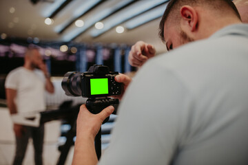 Video camera operator working with his equipment at indoor event.