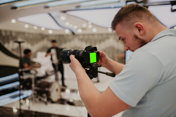 Video camera operator working with his equipment at indoor event.