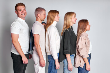 side view on group of youth standing in a row in descending order, beautiful people in casual wear...