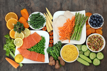 Healthy food for dieting concept with fresh salmon, chicken, vegetables, fruit and corn dip high in protein, omega 3, antioxidants, anthocyanins,  minerals, vitamins, fibre, fibre and lycopene. 