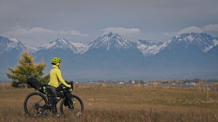 The woman travel on mixed terrain cycle touring with bikepacking. The traveler journey with bicycle bags. Sport tourism bikepacking.