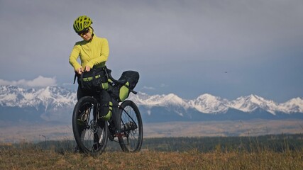 The woman travel on mixed terrain cycle touring with bikepacking. The traveler journey with bicycle bags. Sport tourism bikepacking.