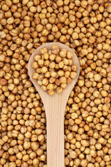Vegan roasted spicy chickpeas in a wooden spoon and forming a background. Health food high in fibre, vitamins, minerals  & protein. Flat lay, top view.