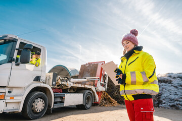 Manager registering truck unloading biomass in compost works