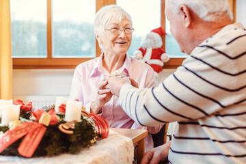 Seniors in nursing home exchanging presents for Christmas