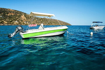 Sea landscape with the self drive motor boat for rent in white and green color on a sea during...