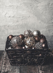 vintage christmas, new Year toys and decoration in basket on brown wooden table with garlands, copy space