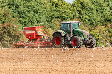 Farmer with tractor and seed drill during sowing and field cultivation - 0811