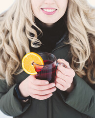 Beautiful woman drinks hot mulled wine outdoor.