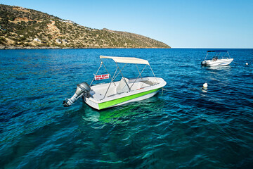 Sea landscape with the self drive motor boat for rent in white and green color on a sea during...
