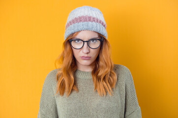 Closeup frowned young woman, isolated on yellow background. Angry girl