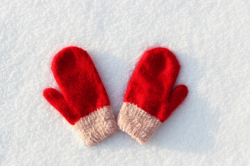 Red mittens lie on the snow. mitten lying on the snow in winter. Holiday Decorations Christmas and New Year Traditions Panoramic Banner Free Space Text Top View Flst lay. Christmas winter background