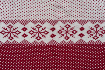 Norwegian Pattern Of Red And White Yarn. Fair Isle Ornament At Cozy Knitted Cloth. Wallpaper. Yarn Knitted Background.