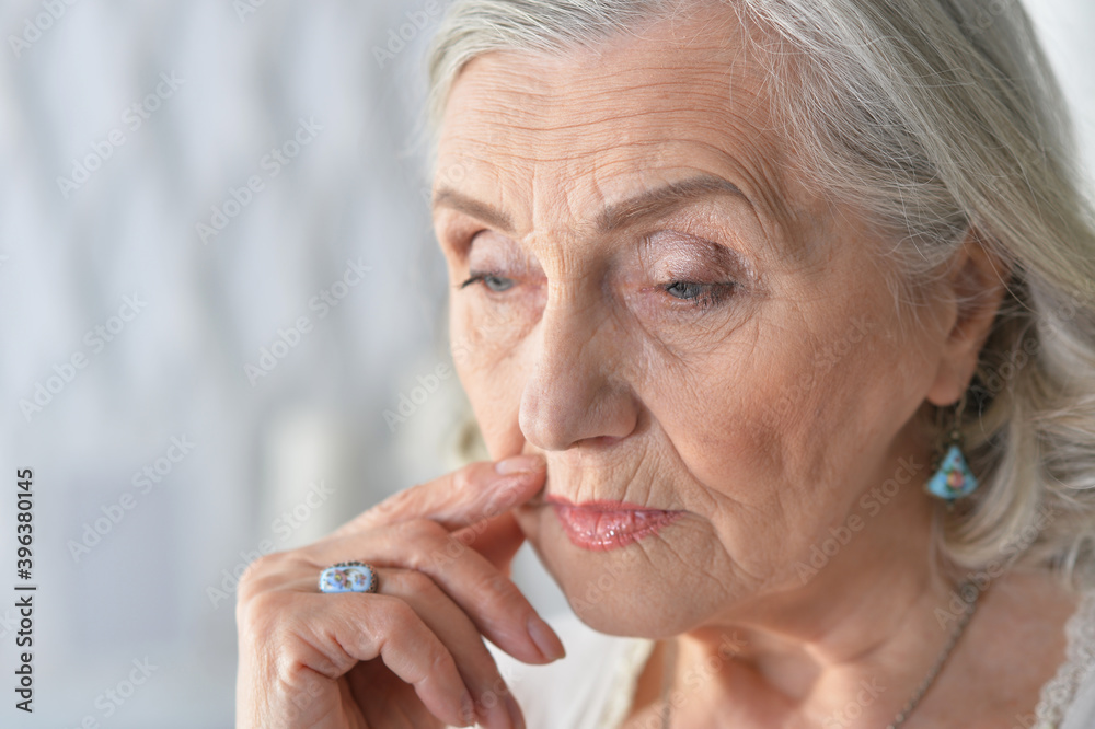 Poster Close up portrait of sad ill senior woman