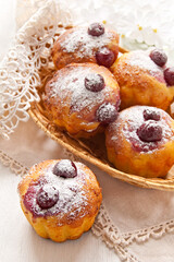 Homemade cupcake with cherries in a wicker basket on a white background