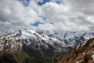 Fototapeta na wymiar High in the Alps. Snow-capped mountain slopes. Low clouds in the lowlands of the forest.