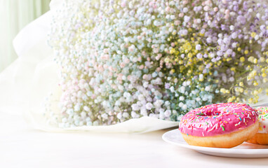 European breakfast with donuts and a bouquet of gypsophila