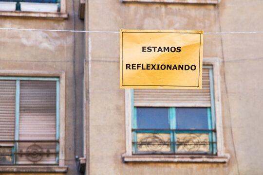 Cartel con un mensaje "Estamos reflexionando" Colgado en la calle. Vista de frente