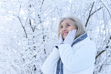 Beautiful senior woman posing in snowy winter park