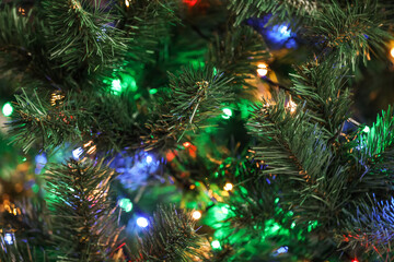 Obraz na płótnie Canvas Christmas tree with bright string lights, closeup. Bokeh effect