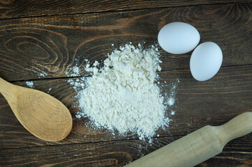 chicken eggs and flour on a wooden background, the concept of making dough