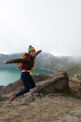 girl photographer jumping in spectacular landscape lagoon inside quilotoa volcano ecuador latin america