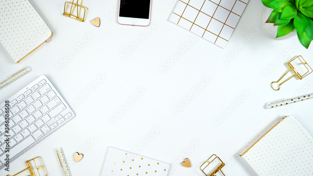 Wall mural stylish white and gold theme desktop workspace with keyboard, notebooks and smart phone. top view bl