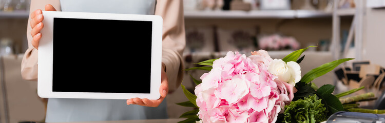 Cropped view of florist holding digital tablet with blank screen near hydrangea on blurred background, banner