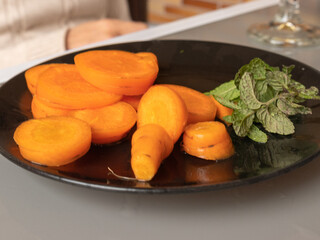 BLACK PLATE WITH FRESHLY PICKED CARROTS FROM THE URBAN GARDEN