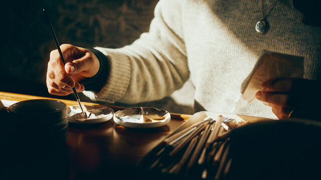 artist's hands and materials in the sun