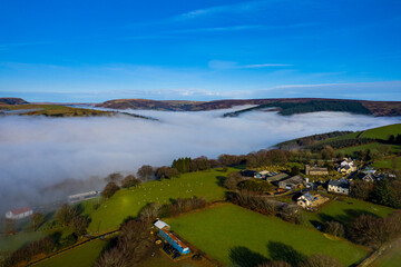 Beautiful morning of drone footage overlooking welsh sceneray with fog sheet covering the lower valleys in south wales uk.