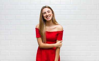 blonde woman laughing shyly and cheerfully, with a friendly and positive but insecure attitude