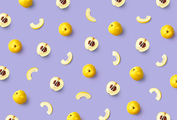 Colorful fruit pattern of fresh quinces on purple background