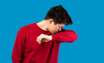 Asian man showing correct sneezing, coughing in his elbow