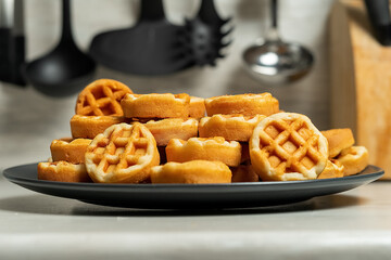 White glass plate with soft waffle on wooden table.