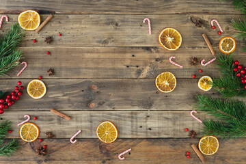Wooden background with Christmas decorations and orange slices. Copy space.