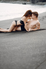 couple relaxing at a secluded private beach in Bali Indonesia. couple showing affection on a hidden beach. Couple wearing bathingsuits