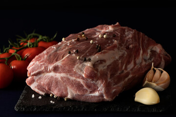 pork, fresh meat with spices and salt on black. raw steak, tenderloin with tomatoes and garnished. semi-finished meat. dish ingredient