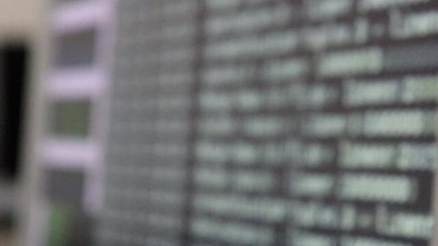 White computer software code moving on a black monitor reflect on glass defocused. Abstract computer hacking in process with rack server base, dynamic text running and flowing on pc screen