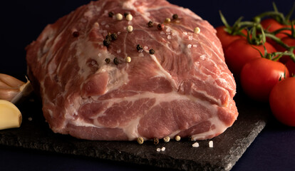 pork, fresh meat with spices and salt on black. raw steak, tenderloin with tomatoes. semi-finished meat. dish ingredient