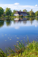 Nice view of the Jaunpils lake and a two-storey house on the shore.