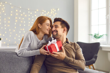 Happy young man holding Valentine gift, smiling and thanking his girlfriend for present - Powered by Adobe