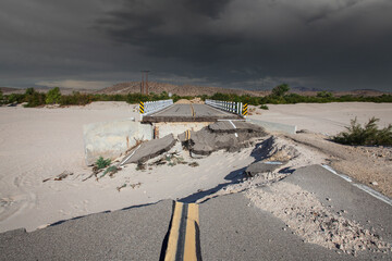 Washed out flood damaged highway bridge with thunderstorm sky in the Mojave desert near Barstow,...