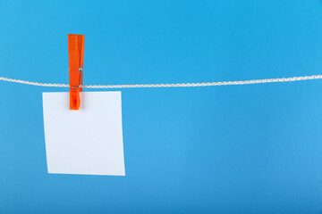 empty sheet of paper hanged with a clothespin on a rope