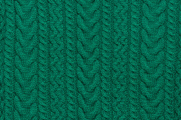 Close Up Of Green Handmade Knitwear With Ornaments, Braids and Arcanes. Knitting Background or Wallpaper Template