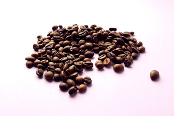 Coffee beans scattered on a pastel background, side view, close-up, space for text