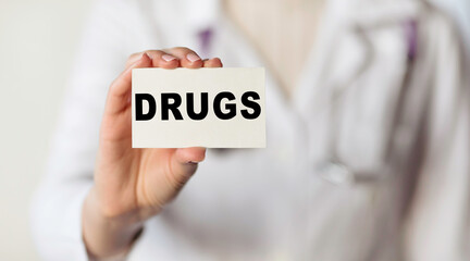 Doctor holds a card with the word DRUG, medical concept. Medical concept.