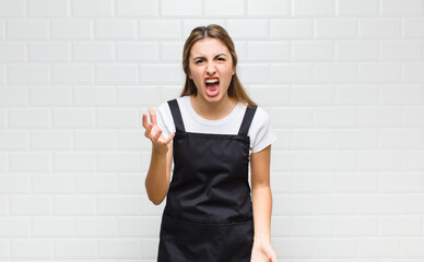blonde woman looking angry, annoyed and frustrated screaming wtf or what’s wrong with you