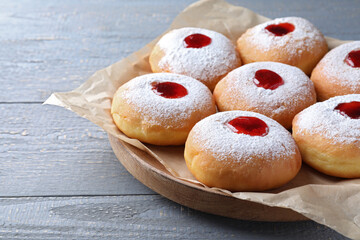 Hanukkah doughnuts with jelly and sugar powder on grey wooden table, closeup
